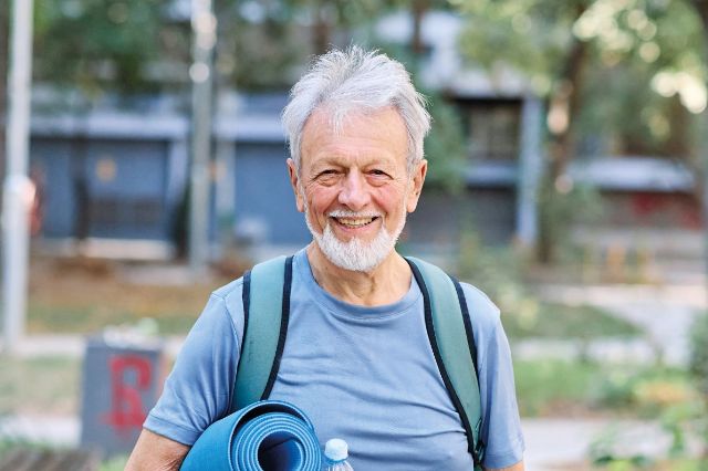 Senior mit Yoga-Matte