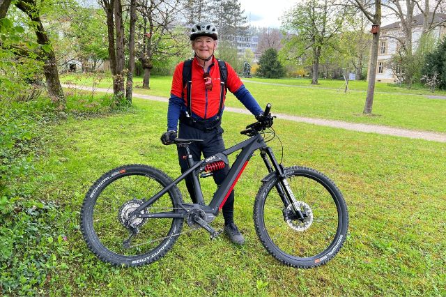 Der E-Mountainbike Leiter zeigt sein Bike und erzählt über die Touren im Wald.