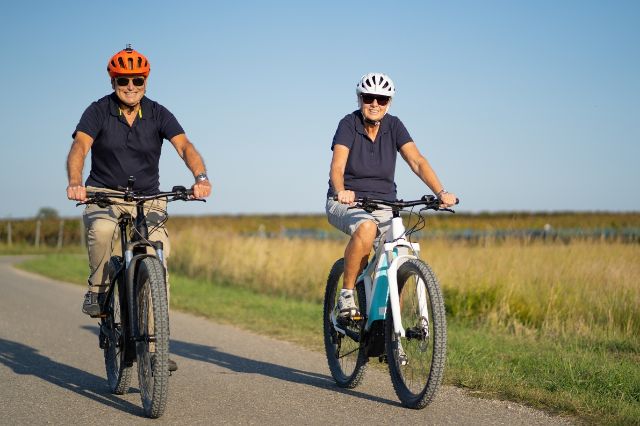 Zwei ältere Personen fahren mit ihren e-Mountainbikes durch die Gegend.